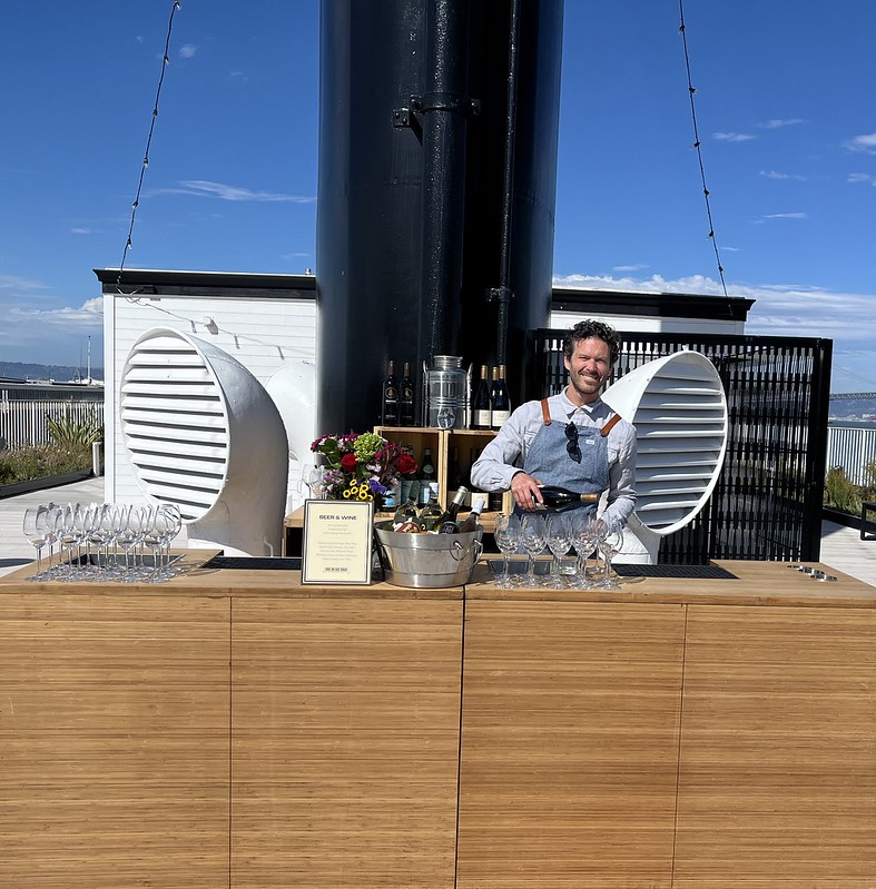 roof deck bar setup with drinks and cocktails with smiling bartender